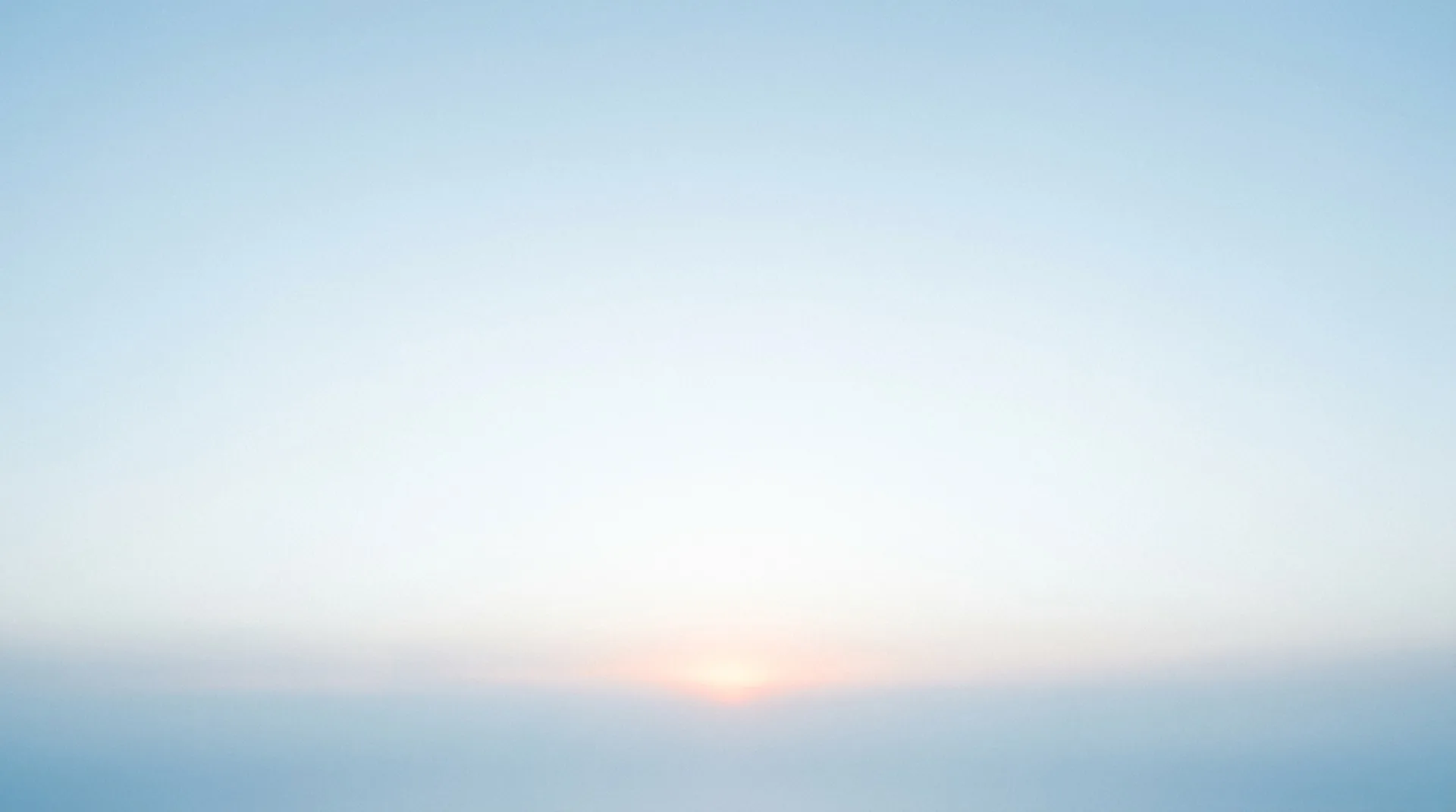 A soft cool summit sky with a faint warm horizon glow